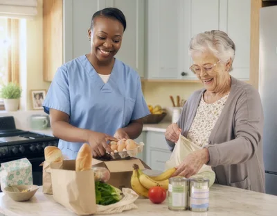 Caregiver Helping Senior Woman Unpack Groceries