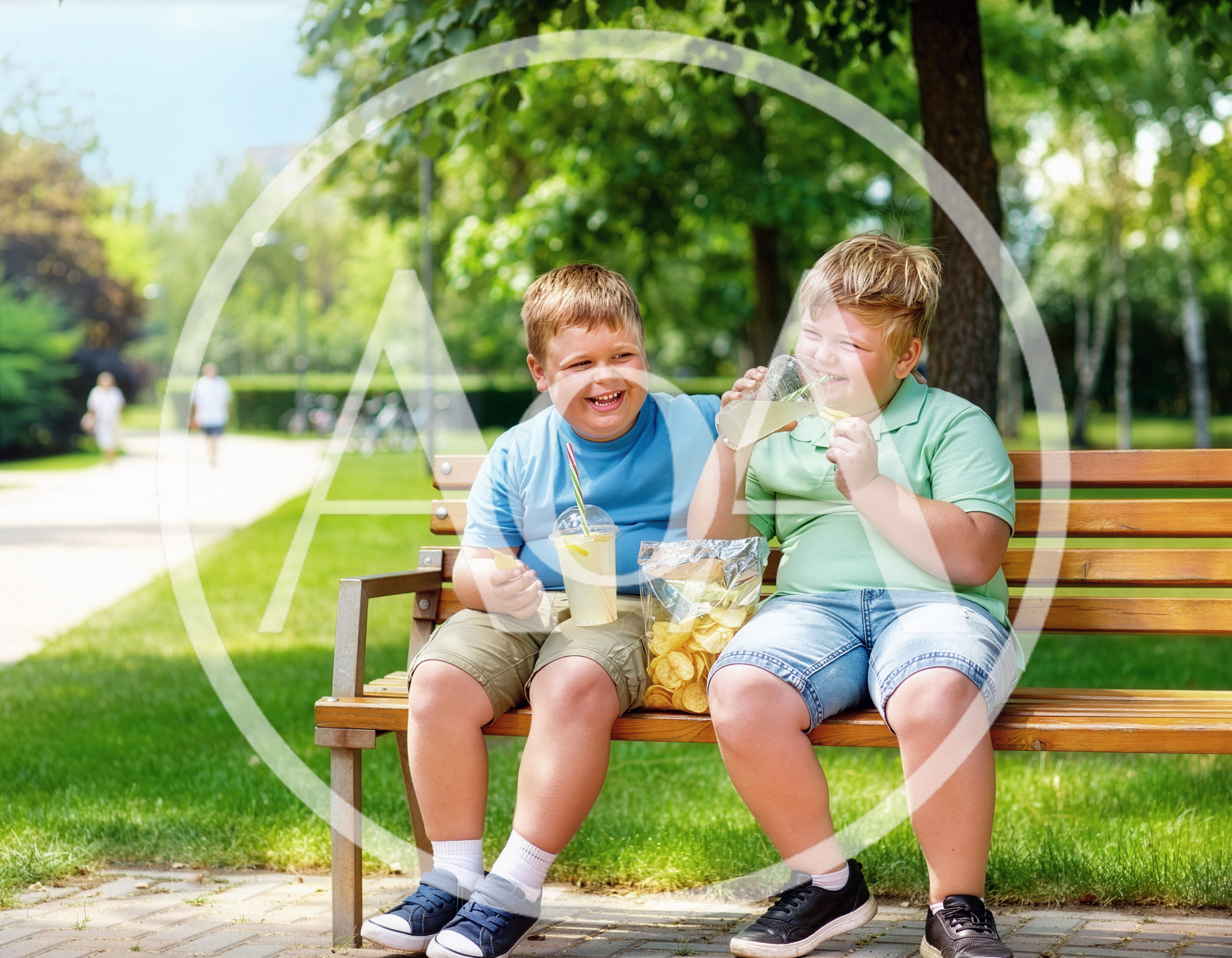 Two Happy Boys Eating Snacks on a Park Bench