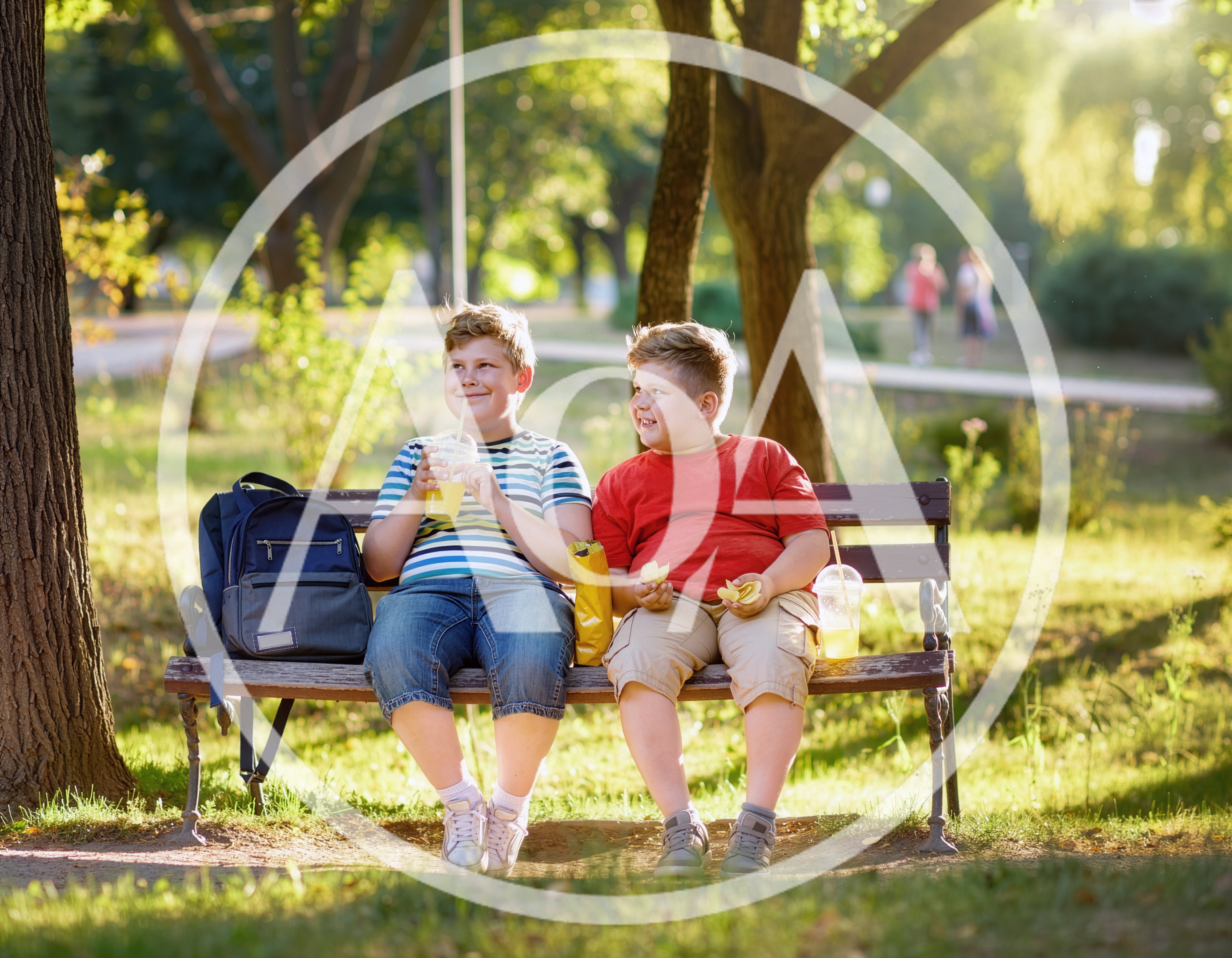 Two Young Boys Eating Snacks on a Park Bench
