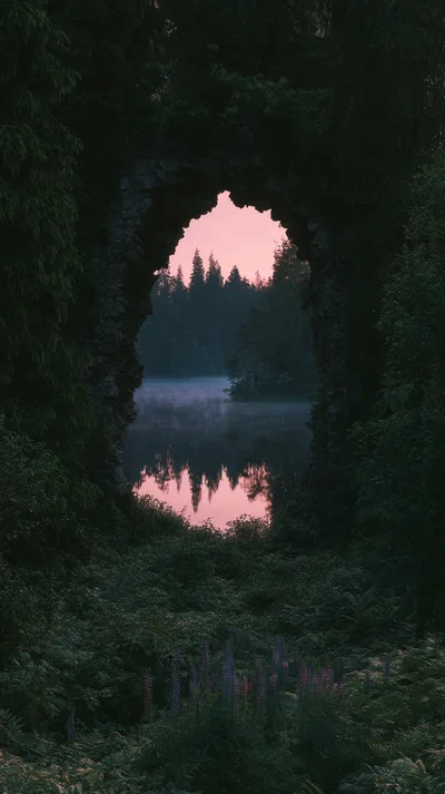 Stone Archway Overlooking A Misty Forest Lake At Sunset