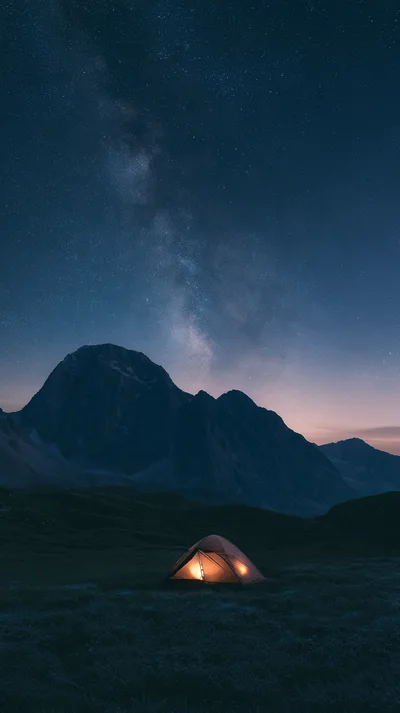 Illuminated Camping Tent Under Milky Way Galaxy