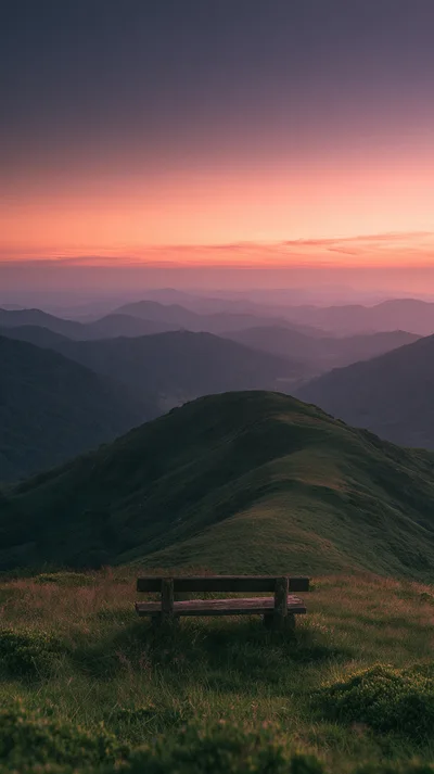 Wooden Bench Overlooking Rolling Mountain Range at Sunset