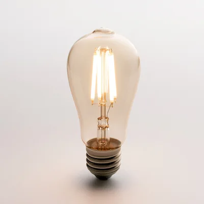 Glowing LED Filament Light Bulb On White Background