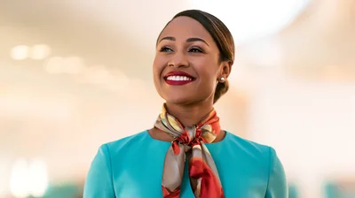 Smiling Flight Attendant Looking Upwards