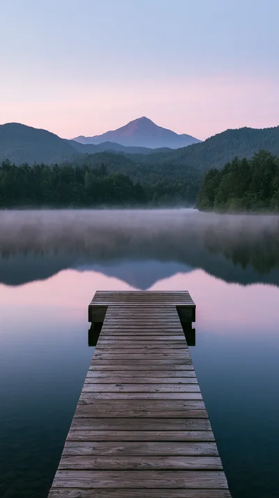 Wooden Dock Extending Into A Calm Misty Mountain Lake