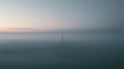 Communication Tower Rising Above Thick Morning Fog