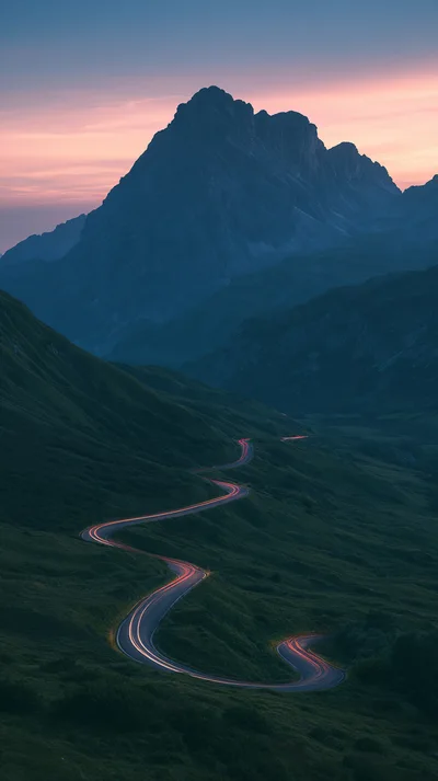 Winding Mountain Road With Car Light Trails At Dusk