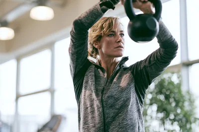 Woman Exercising With Kettlebell In A Gym