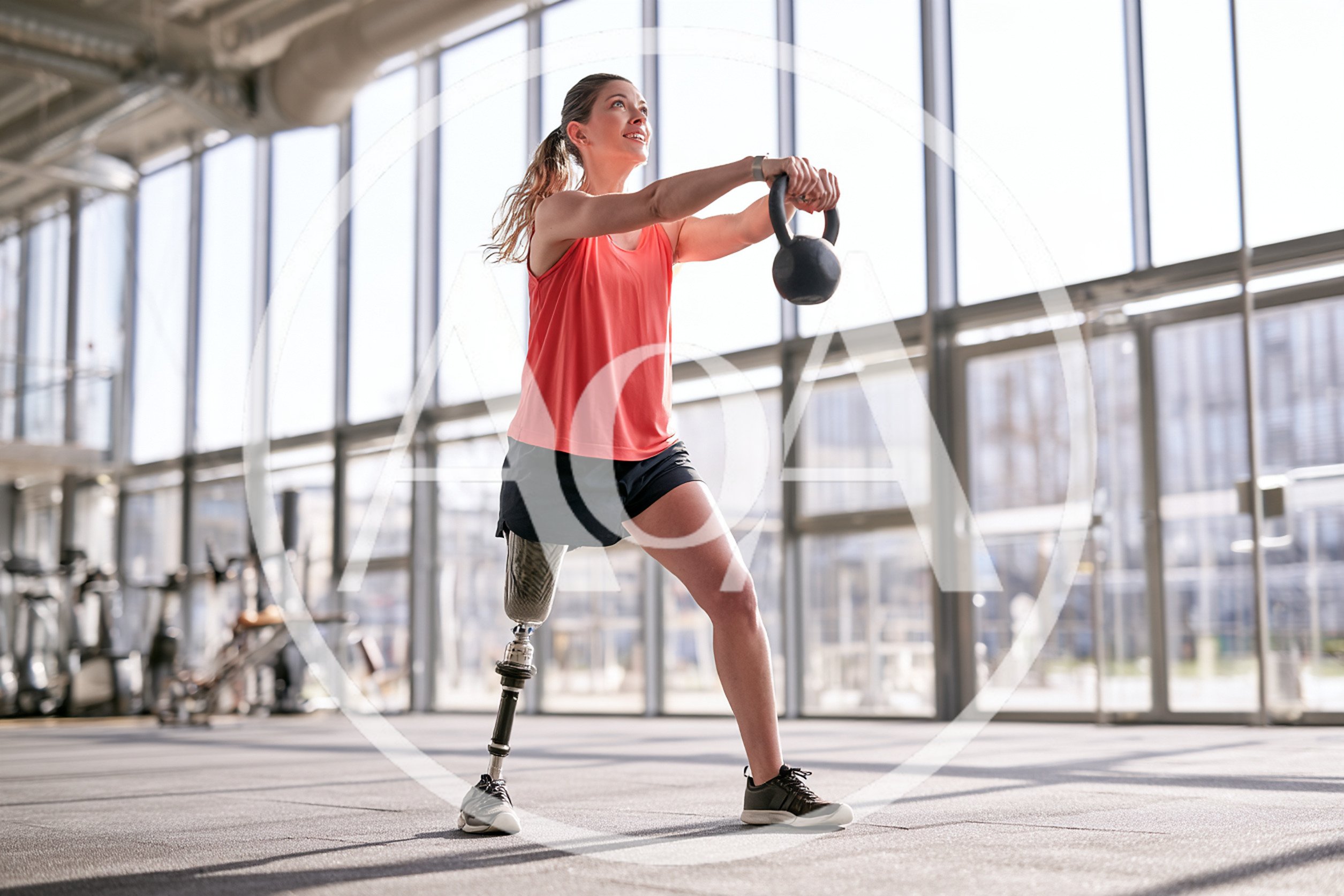 Amputee Woman Exercising With Kettlebell In Modern Gym