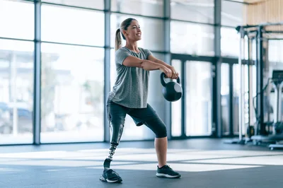 Woman With Prosthetic Leg Performing Kettlebell Squats