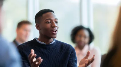 Young Black Man Speaking During A Group Discussion