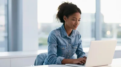 Young Woman Working On Laptop In Modern Office