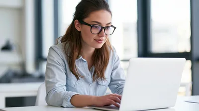 Young Woman Working On Laptop In Modern Office