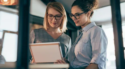 Two Professional Women Collaborating on a Digital Tablet