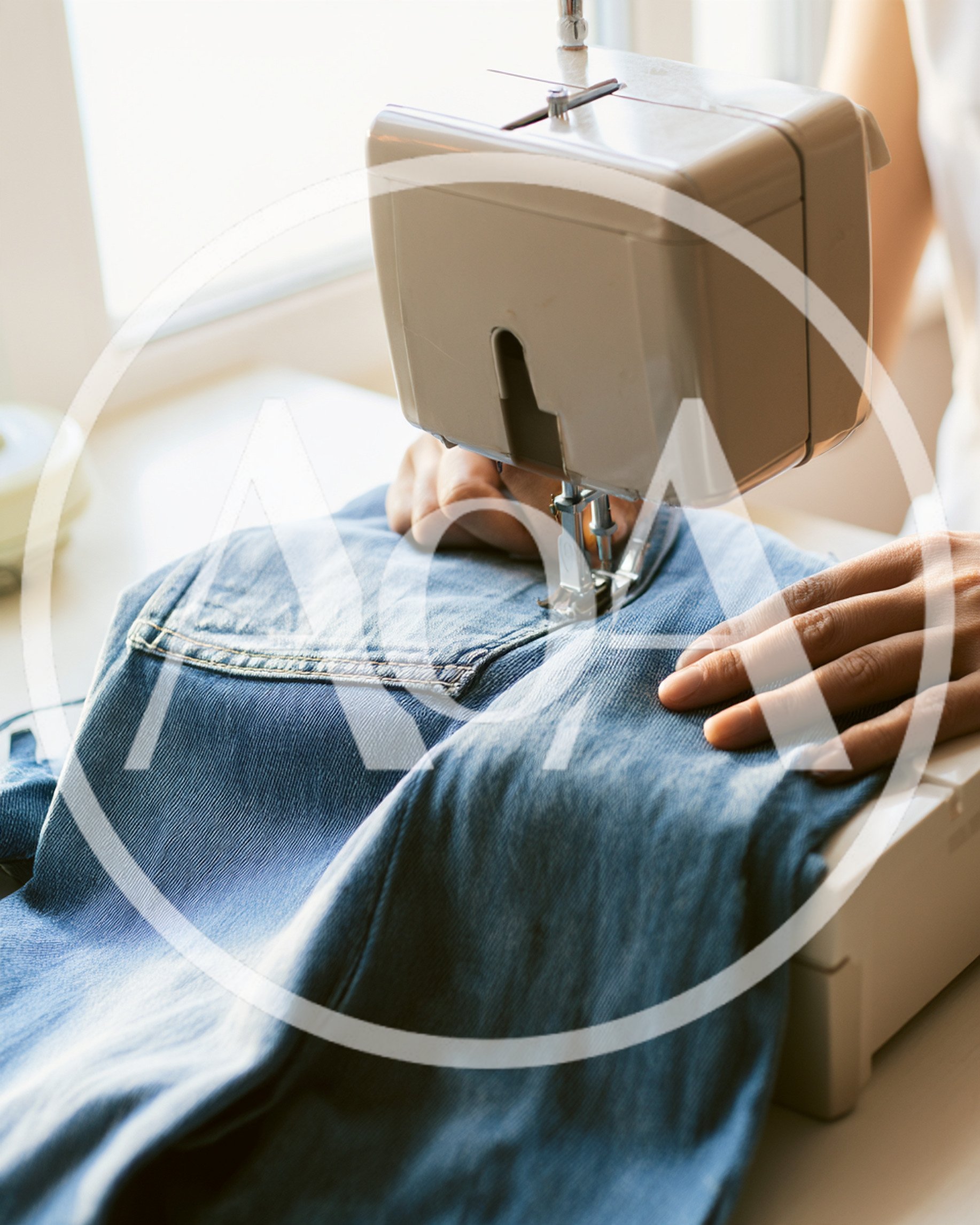 Person Sewing Denim Jeans With A Sewing Machine