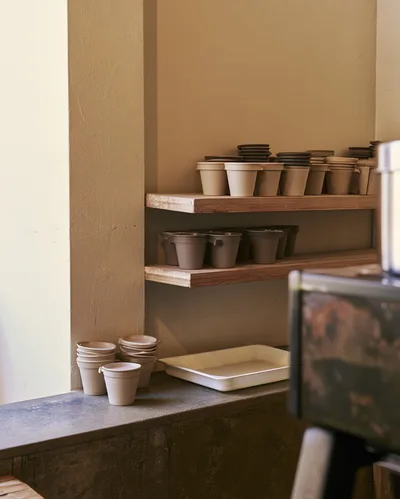 Stacked Ceramic Cups On Wooden Shelves In Cafe