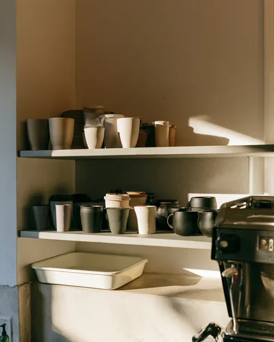 Ceramic Coffee Cups Arranged On Cafe Shelves
