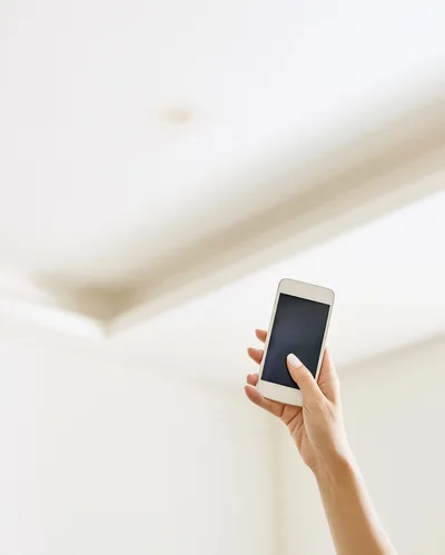 Hand Holding Smartphone Against Bright Minimalist Background