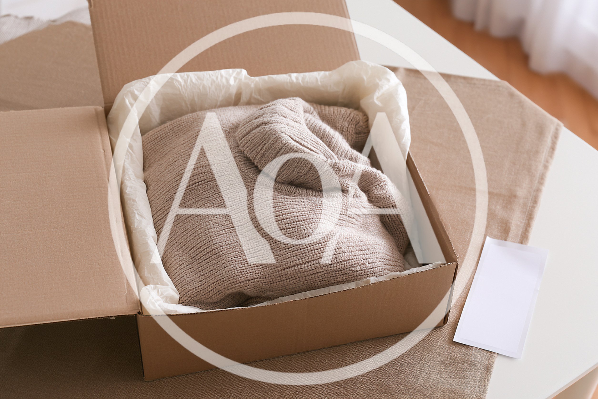 Beige Knitted Sweater Inside A Cardboard Shipping Box
