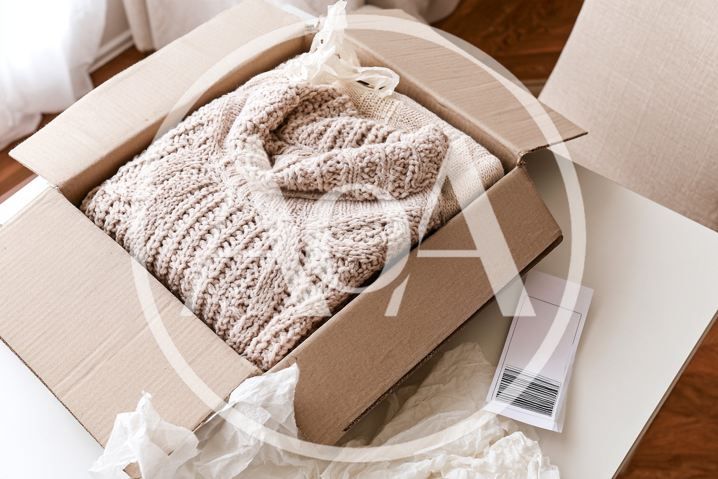 Beige Knitted Sweater Inside A Cardboard Shipping Box