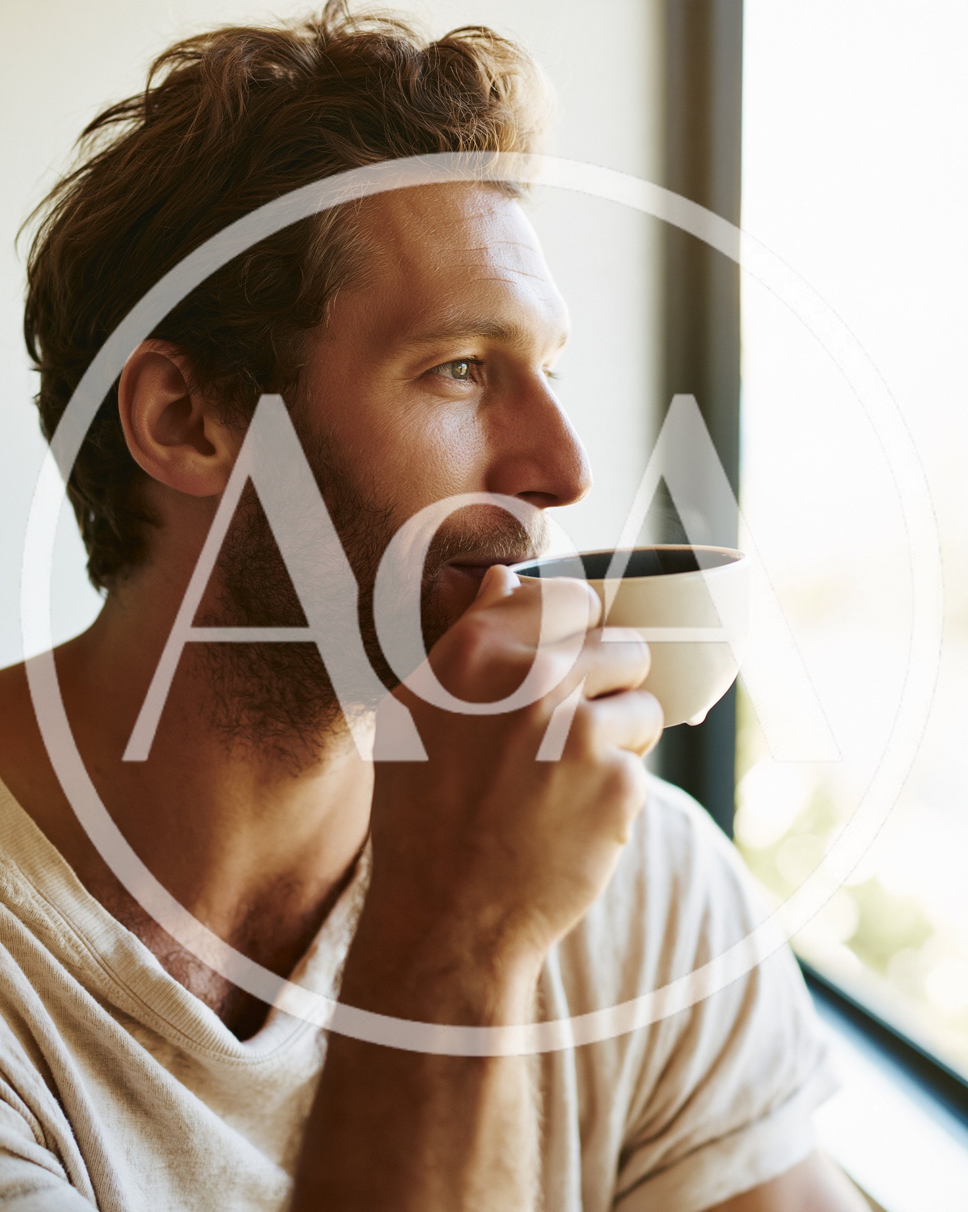 Man Drinking Coffee While Looking Out A Window