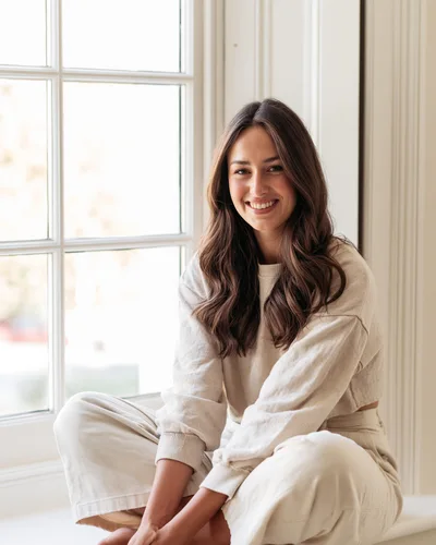 Young Woman Smiling While Sitting By A Window