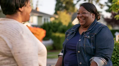 Two Women Laughing Together Outdoors In A Neighborhood