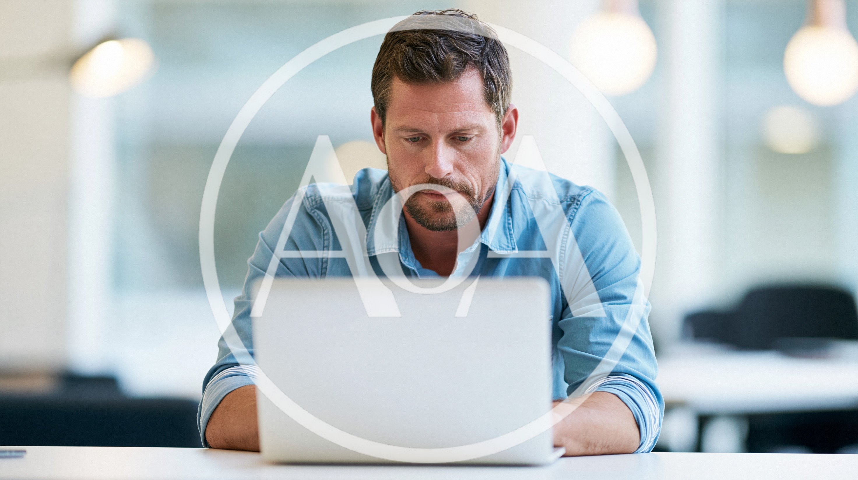 Focused Businessman Working On Laptop In Modern Office