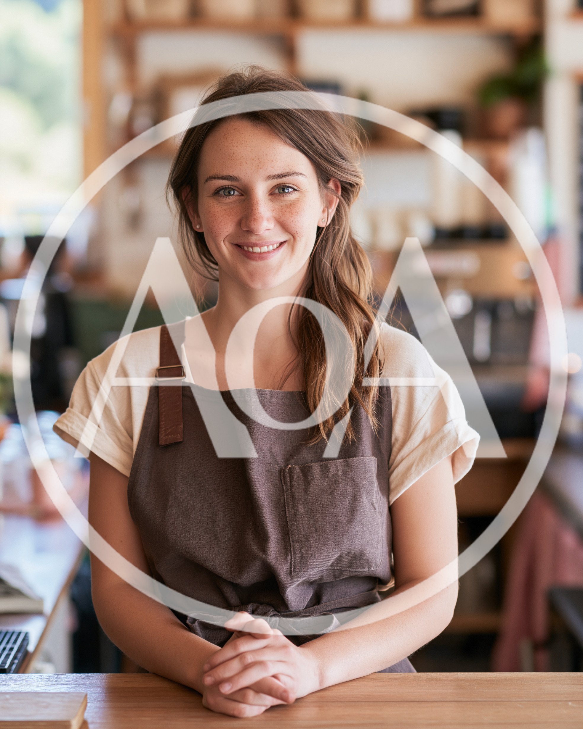 Friendly Female Barista Smiling Behind Coffee Shop Counter