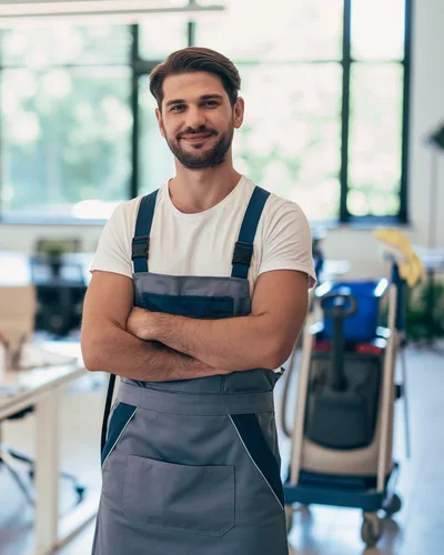 Professional Male Janitor Standing In Modern Office