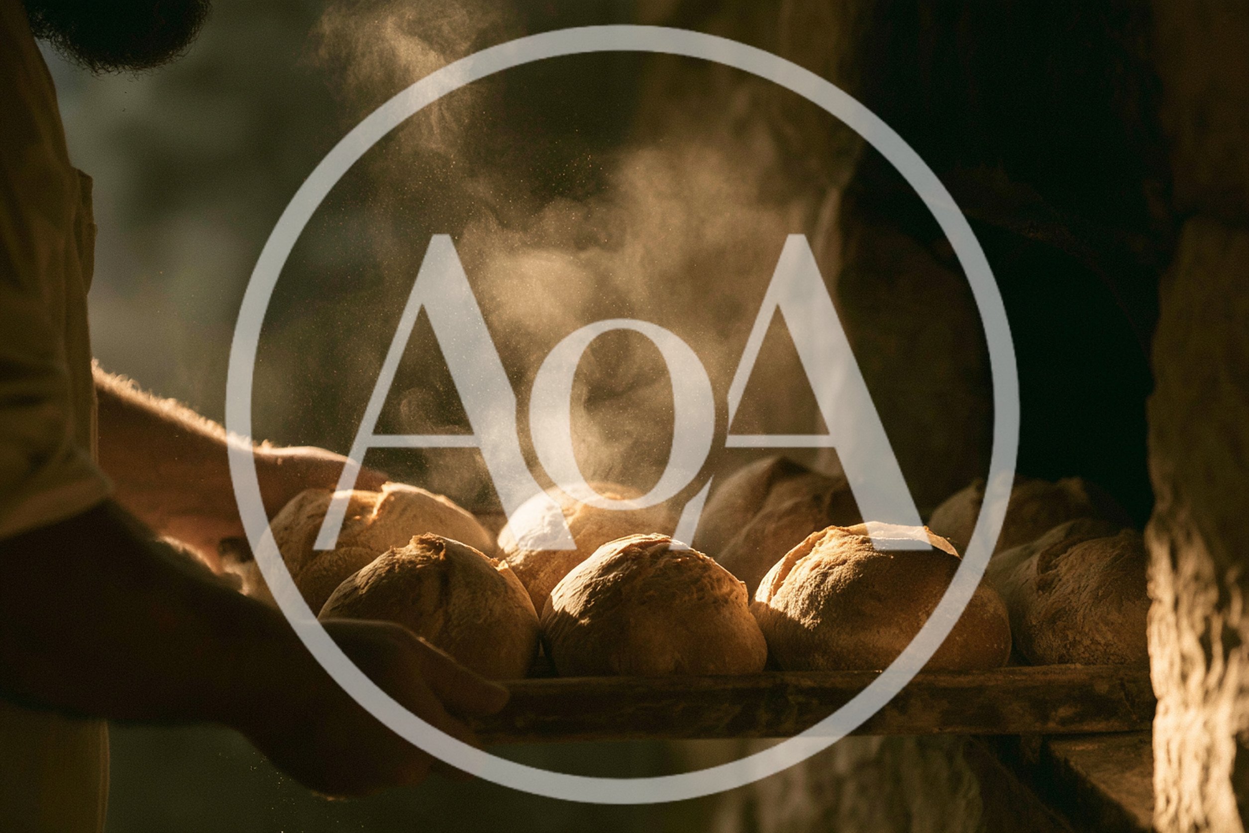 Baker Removing Freshly Baked Sourdough Loaves From Oven