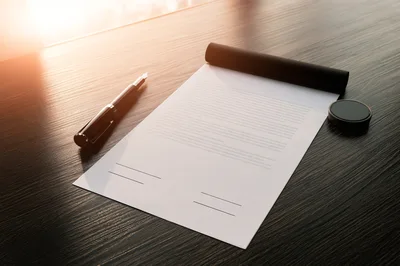 Fountain Pen and Contract on Dark Wooden Desk