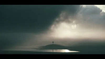 Lone Person Standing On A Misty Barren Landscape