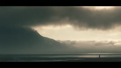 Lone Person Standing On A Vast Misty Shoreline