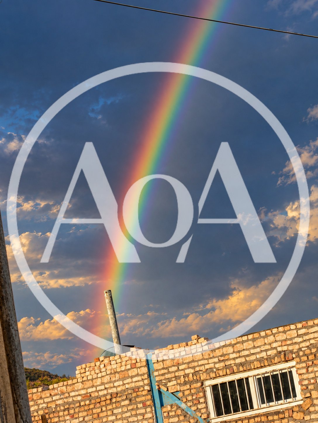 Vibrant Rainbow Appearing Above A Partially Constructed Brick Building