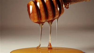 Honey Dripping From A Wooden Dipper