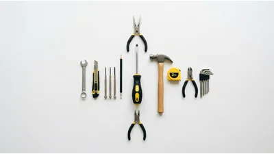 Assorted Hand Tools Arranged On White Background