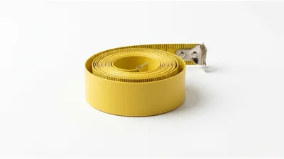 Yellow Measuring Tape Coiled on White Background