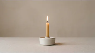 Lit Taper Candle In Minimalist Ceramic Holder