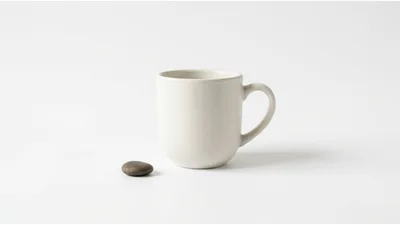 Minimalist White Ceramic Mug And Small Stone