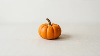 Small Orange Pumpkin On A Neutral Linen Background