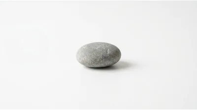 Single Smooth Grey River Stone On White Background