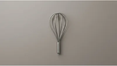 Minimalist Stainless Steel Kitchen Whisk On Grey Background