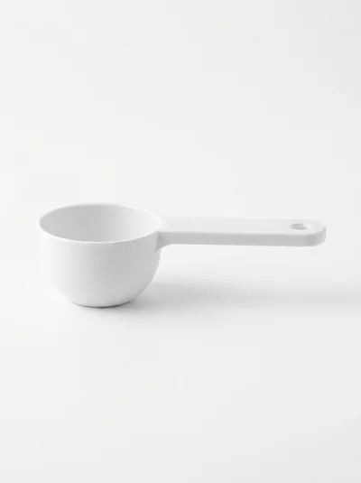 White Plastic Measuring Scoop On White Background