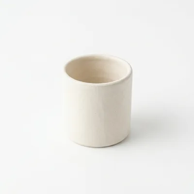 Minimalist Beige Ceramic Cup On White Background
