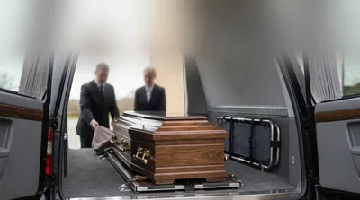 Funeral Directors Loading Casket Into Hearse