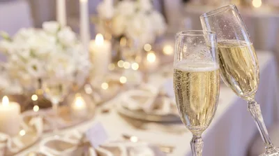 Two Champagne Flutes Toasting At A Wedding Reception