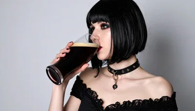 Goth Woman Drinking Dark Beer From A Glass
