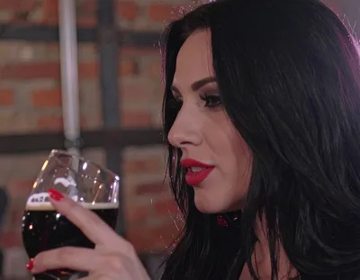 Beautiful Woman Drinking Dark Beer In A Pub