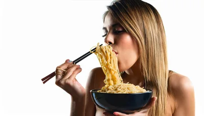 Young Woman Eating Noodles With Chopsticks